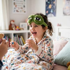 Mặt nạ ngủ đặt cạnh chăn gối trên giường